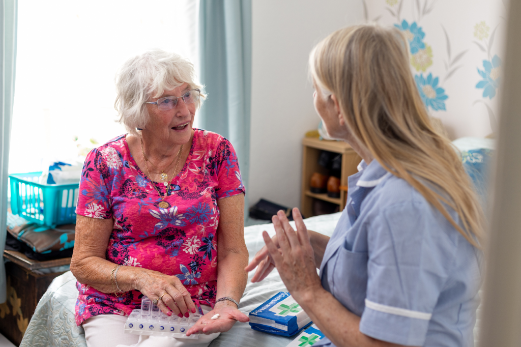 Nurse discussing medicine with elderly patient