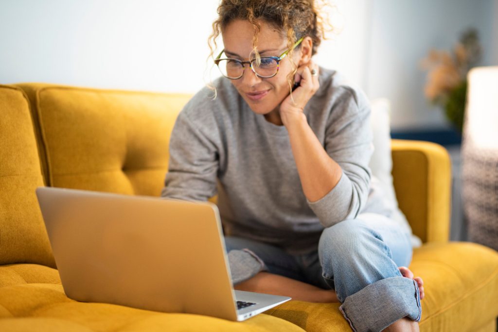 Female sitting on couch using laptop